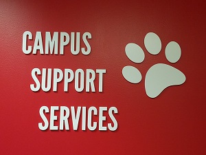 Campus Supports Services sign on a red wall